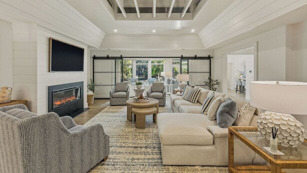 A spacious living room with a fireplace, comfortable seating, and a view of the outdoors.