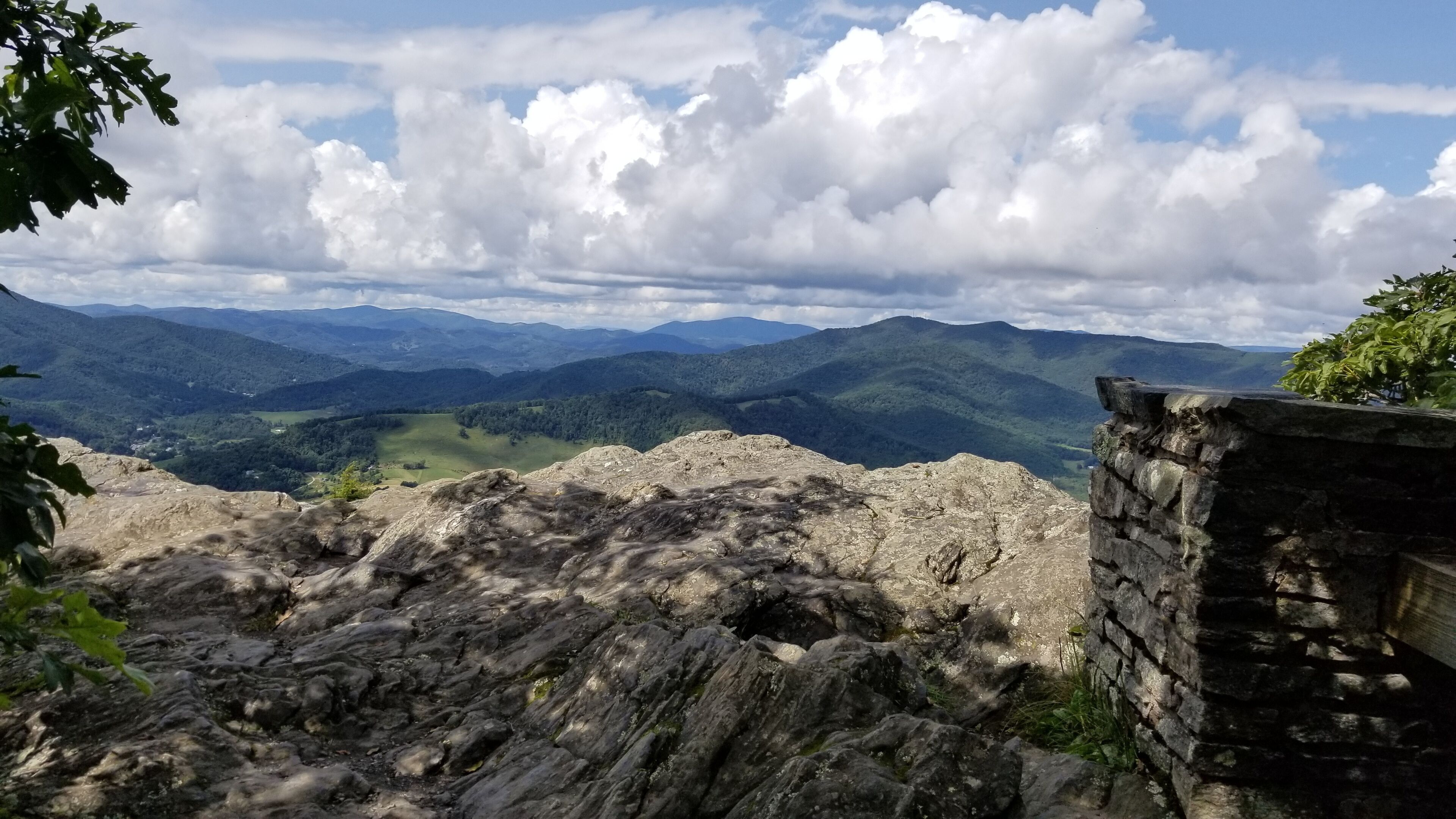 A rocky landscape with a stone wall and a view of distant mountains.