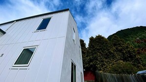 A modern building with a white facade and multiple windows. - RIMA | Sun-Soaked Hideaway (Queenstown)