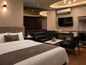 A hotel room with a bed, a desk, a television, and a wardrobe. - 648 Hotel (Seoul)