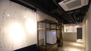 Un interior moderno con una pared de mármol, una vitrina de vidrio y un sofá azul.