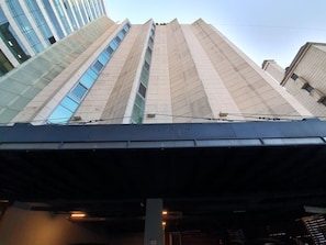 A modern building with a prominent entrance and a sign indicating it is Hotel 048.