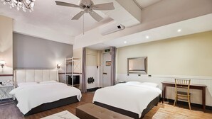 A hotel room with two beds, a desk, a chair, a ceiling fan, and a mirror. - 648 Hotel (Seoul)