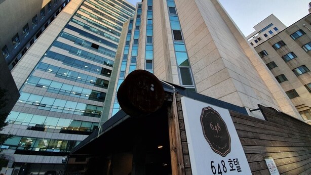 A modern building with a prominent number '648' sign, large windows, and a mix of glass and concrete architecture. - 648 Hotel (Seoul)