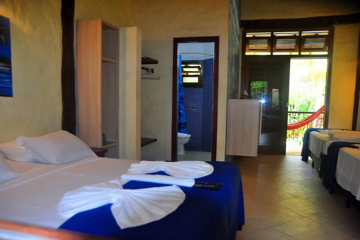 Une chambre d’hôtel avec un lit, une salle de bain et un balcon.