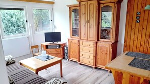 A cozy room with a wooden cabinet, a television, and a dining table.
