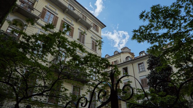 A multi-story building with balconies and windows, surrounded by trees. - The best B&b in town (Torino)