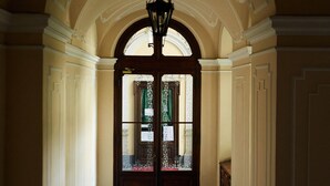 A hallway with a tiled floor, an arched doorway, and a hanging light fixture. - The best B&b in town (Torino)