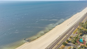 Une route côtière, avec une plage d’un côté et une autre route de l’autre.