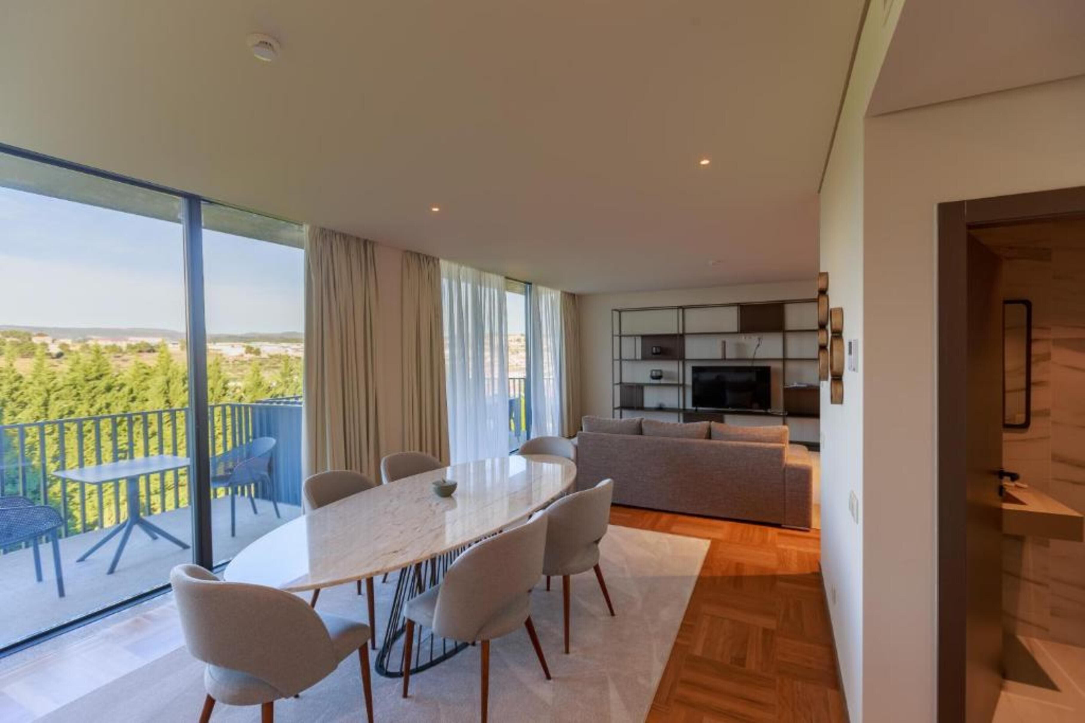 Um apartamento moderno com área de jantar, sala de estar e varanda com vista.