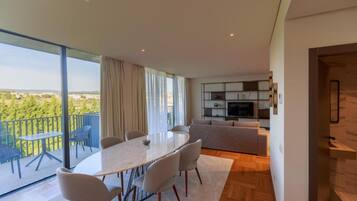 Um apartamento moderno com área de jantar, sala de estar e varanda com vista.