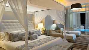 Une chambre à coucher luxueuse avec un grand lit, un coin salon et une vue sur une piscine.