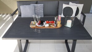 Una mesa de comedor con una bandeja de comida, copas de vino y una vela.