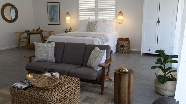 Un dormitorio con cama, sofá, mesa de comedor y armario.
