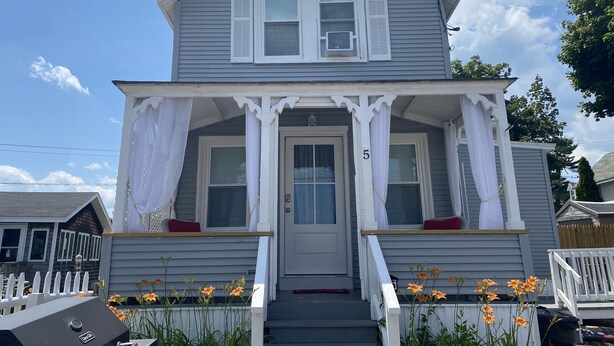 A two-story house with a porch, white shutters, and a number '5' on the door. - Quaint Cottage Vacation (Old Orchard Beach)