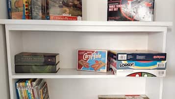 Une bibliothèque contenant divers jeux de société et livres.
