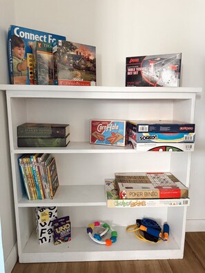 Una estantería con diversos juegos de mesa y libros.