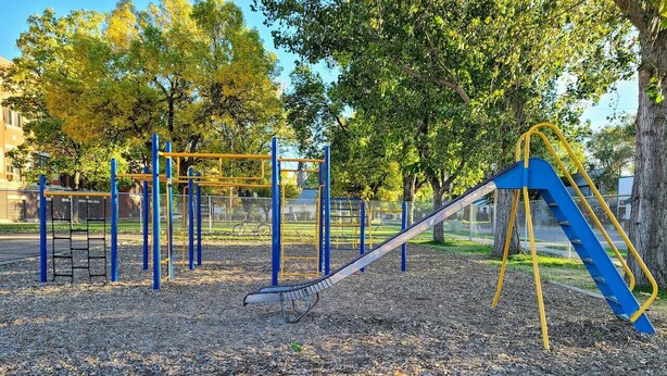 A playground with a slide and climbing structures. - Spacious Upstairs Loft (Miles City)