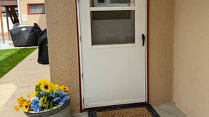 A white door with a glass panel and a welcome mat. - Spacious Upstairs Loft (Miles City)