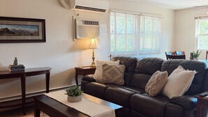 A living room with a leather sofa, a coffee table, a lamp, and a patterned rug. - Spacious Upstairs Loft (Miles City)