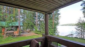 A wooden deck with a bench and a table, overlooking a lake and forested area. - Honkatupa by Interhome (Ruovesi)