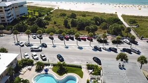 An aerial view of a hotel with a swimming pool, parking lot, and a beach in the background. - Charming Studio Beach Getaway. Beachfront Pool, Near Restaurants, Activities (St. Pete Beach)