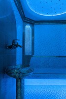 Baño con piso de azulejos, lavamanos y zona de ducha.