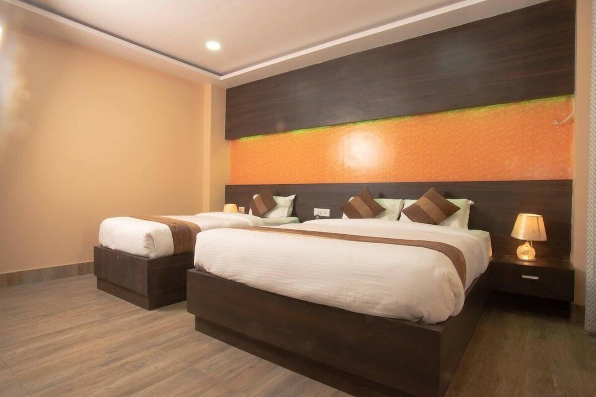 Ein Hotelzimmer mit zwei Betten, einem Nachttisch mit Lampe und einer Wand mit Strukturmuster.