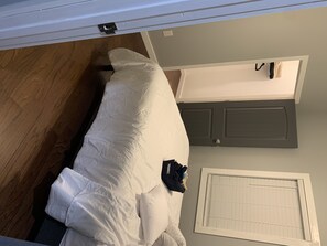 Comfortable room with a bed, door, and window.