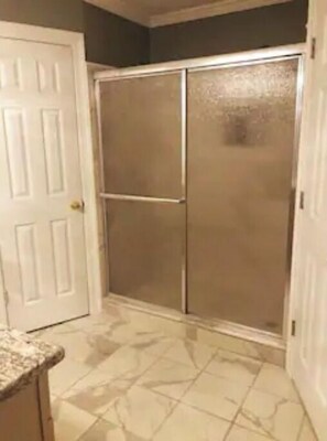 Bathroom features a shower area with a glass door and sliding door.