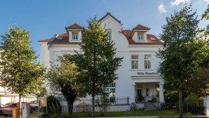 A white building with a red-tiled roof, a sign reading "Villa Annabell," and a gated entrance. - Villa Annabelle Fewo 7 Auszeit - Apartment 7 Auszeit (Binz)