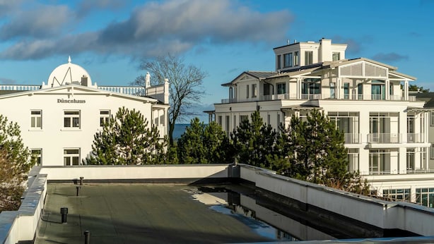 A white building with a dome and the name "Dünenhaus" on the facade. - Villa Annabelle Fewo 7 Auszeit - Apartment 7 Auszeit (Binz)