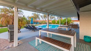 An outdoor patio with a pool, lounge chairs, and a covered seating area. - *Heated Pool Available* | South Scottsdale Paradise (Scottsdale)