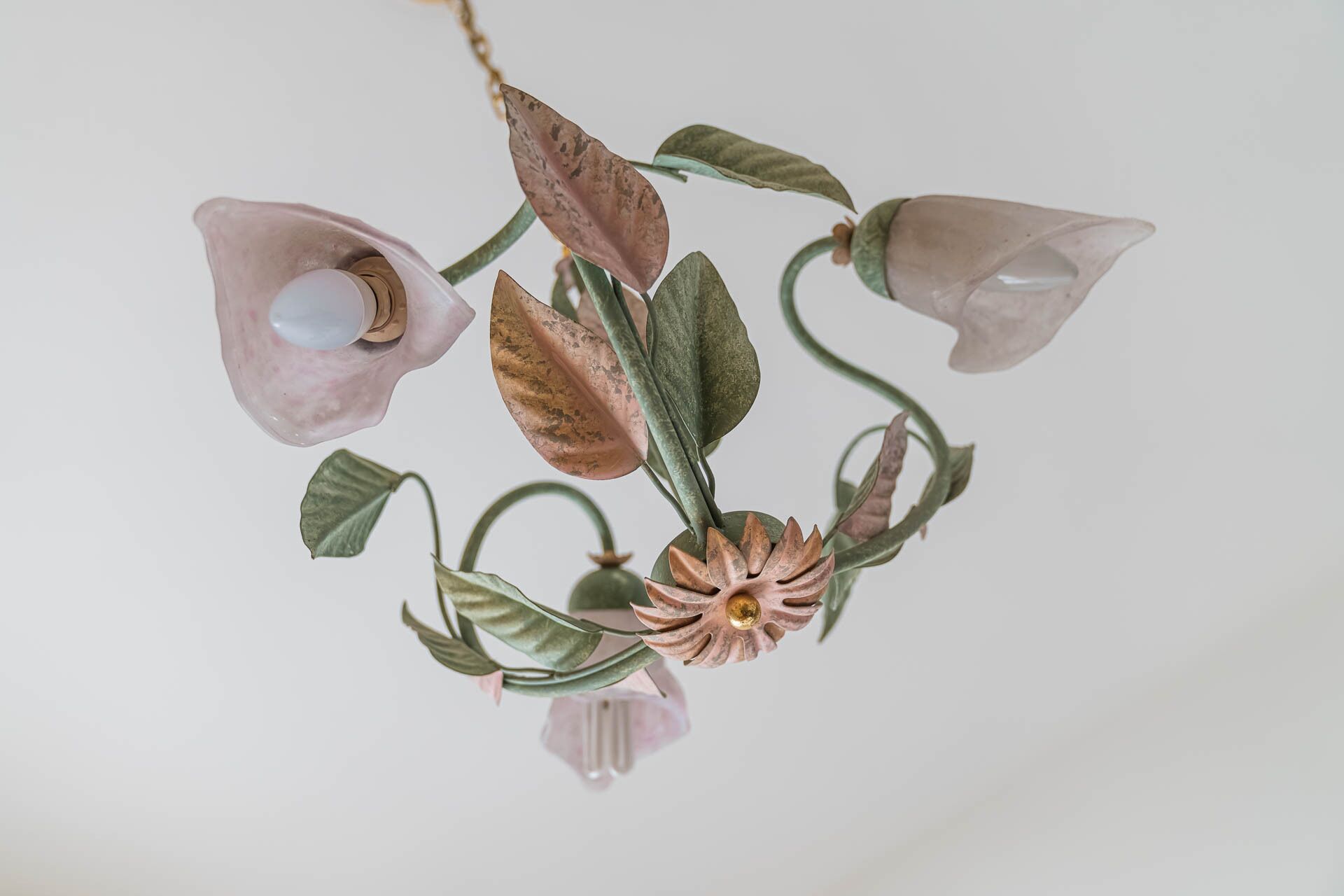 Un lustre doté de plusieurs abat-jours en verre et d’un élément décoratif central.