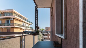 Ein Balkon mit Tisch und Stühlen mit Blick auf die Nachbargebäude.