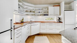 A modern kitchen with white cabinetry, a wooden countertop, and a built-in window. - 6 bedroom gorgeous home in Gilleleje (Gilleleje)