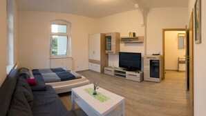 Ein modernes Wohnzimmer mit einer Couch, einem Couchtisch, einem Fernseher und Einbauschränken.