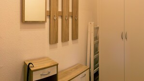 Ein Badezimmer mit einem Holzbadezimmermöbel, einem Spiegel und einem Schrank.