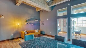 A modern interior with a large table, a sofa, and a dining area. - Sosuite | 2BR Apt w W/D, Gym, On-Site Restaurant (Philadelphia)