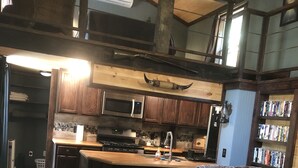 A spacious kitchen with wooden cabinets, a central island, and a built-in microwave.