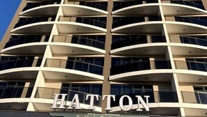 A high-rise building with a modern architectural design, featuring multiple balconies and a prominent sign reading "HATTON SUITES". - Hatton Suites Esenboga (Ankara)