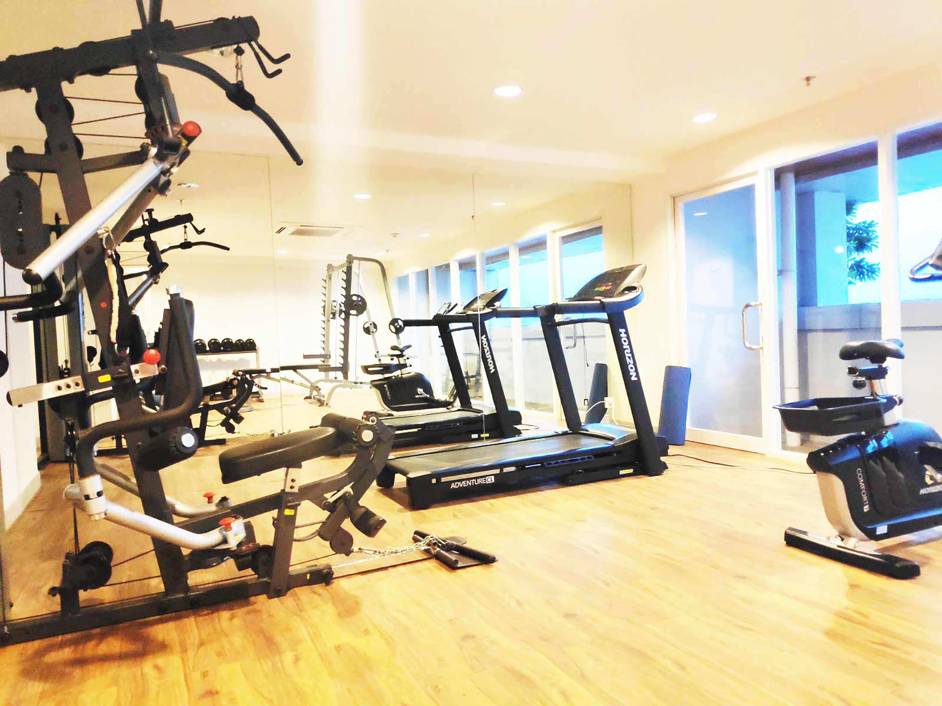 A gym with treadmills, weight machines, and a stationary bike.