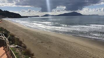 Ein Strand mit freiem Blick auf das Meer und entfernte Berge.