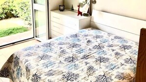Une chambre à coucher avec un lit, une commode, un miroir et un tableau.