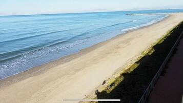Una spiaggia con vista aperta sull'oceano e una passeggiata lastricata lungo la riva.