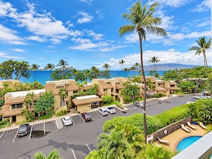A resort with multiple buildings, a parking lot, and a pool area with lounge chairs. - Where Turquoise Waters Beckon Kihei Condo Ocean Views Rooftop Garden Pool (Kihei)