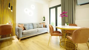 A modern living room with a grey sofa, a round yellow table, and matching chairs.