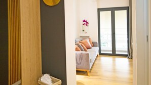 A modern living room with a sofa, a small round table, and a wooden partition.