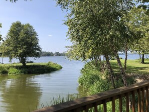 A calm lake with trees and a wooden deck. - The Lake Store Lodging Room #2 (Winnsboro)