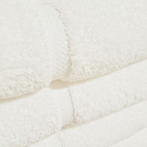 A close-up of a white, fluffy fabric, likely a towel or blanket, with a textured surface and a folded edge. - The Lake Store Lodging Room #2 (Winnsboro)